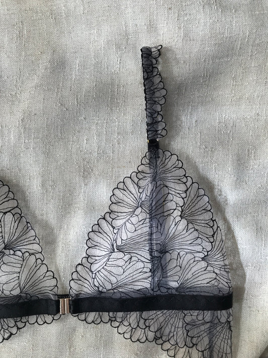 Close-up of a lace trim with floral patterns on a textured fabric background