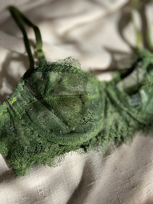 Close-up of green lace fabric on a textured beige background