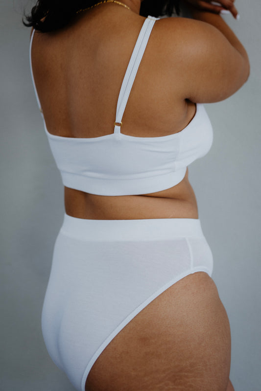 This image features a model wearing a Bamboo Full Brief, a pair of women's underpants that emphasize comfort and eco-friendliness. The knickers are made from bamboo fabric, which offers hypoallergenic properties, making them ideal for sensitive skin.