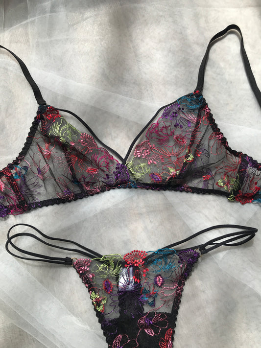 This image features the Calithea Bralette, an elegant piece of intimate apparel. The bralette is adorned with a delicate floral pattern on a sheer black background, emphasizing its sophisticated and sensual design.