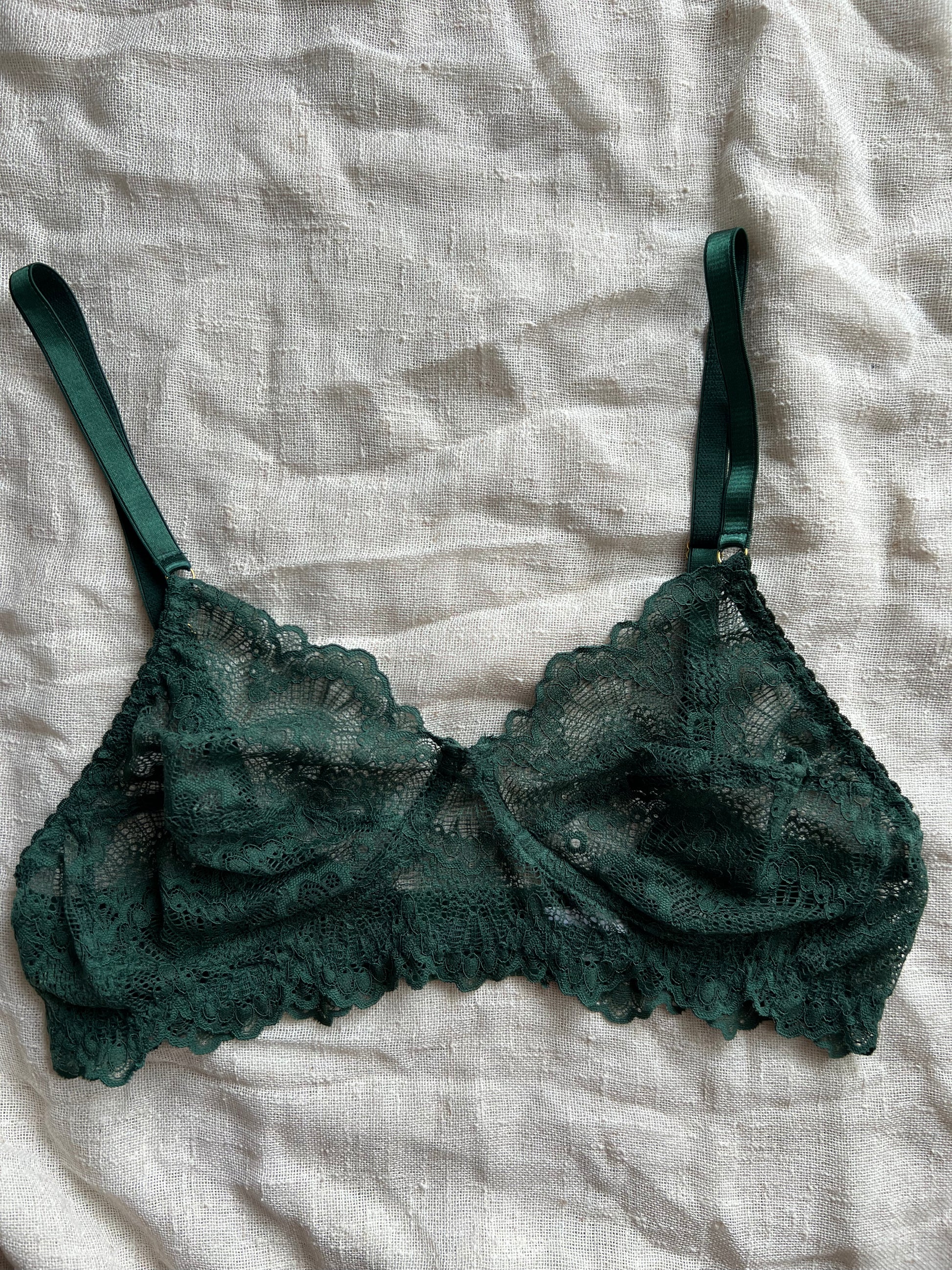 Green lace bra on a light gray fabric background