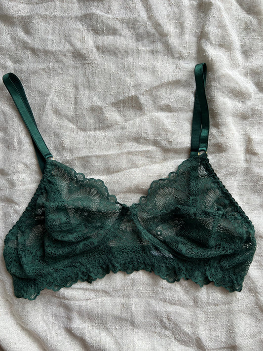 Green lace bra on a light gray fabric background