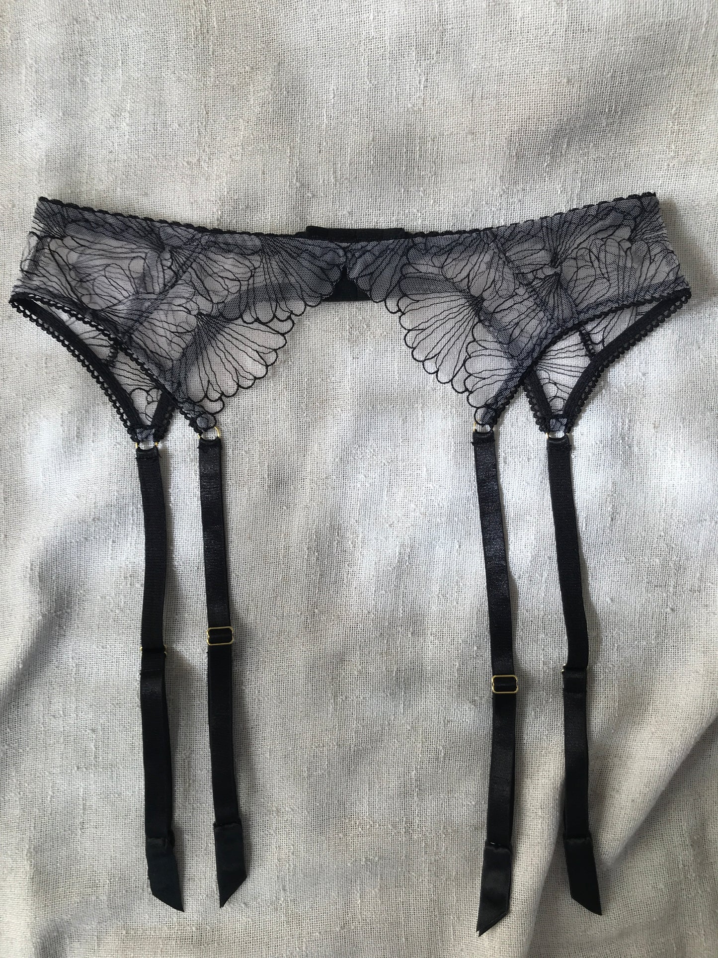 Black lace lingerie set on a light gray fabric background