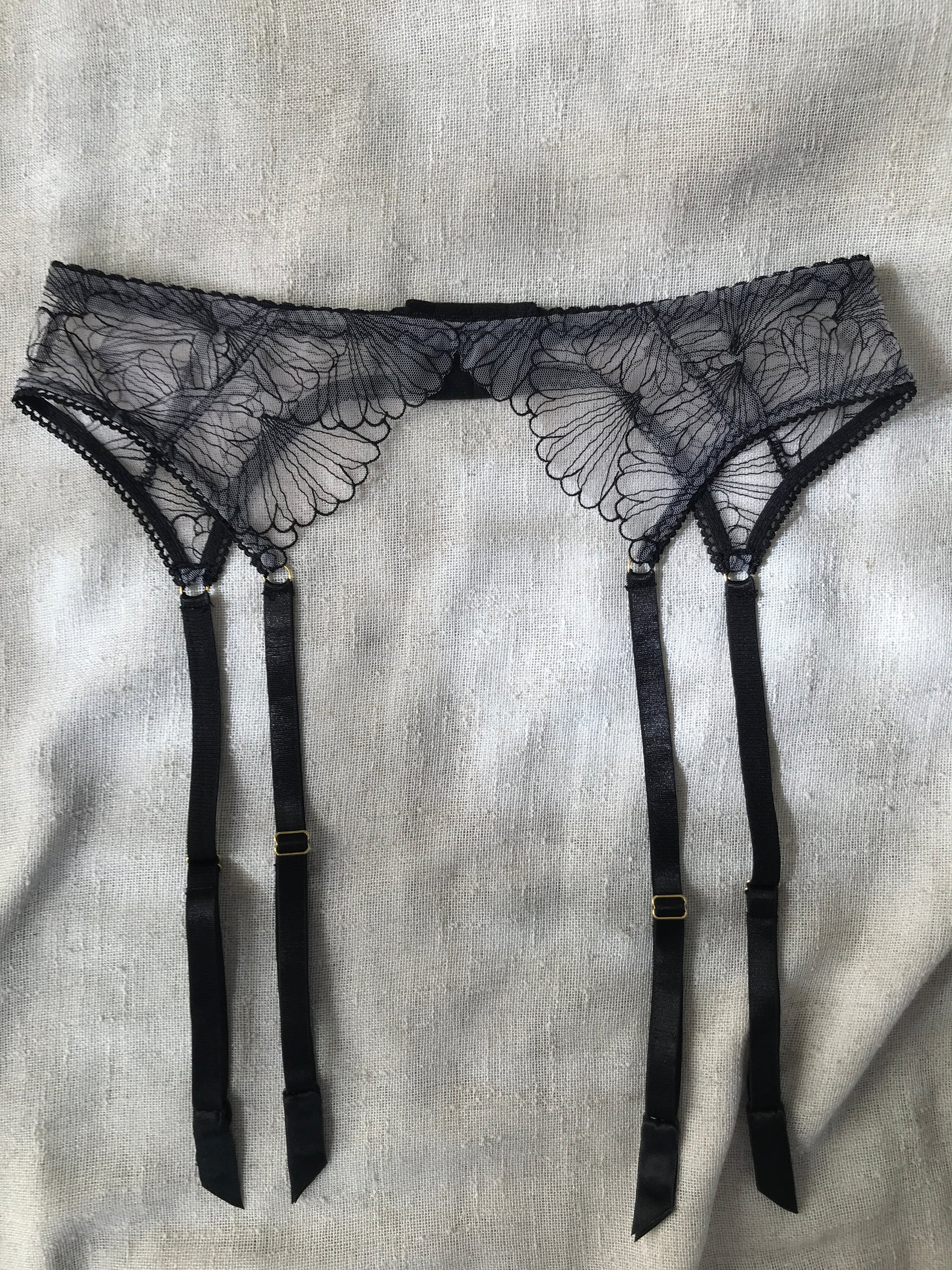 Black lace lingerie set on a light gray fabric background