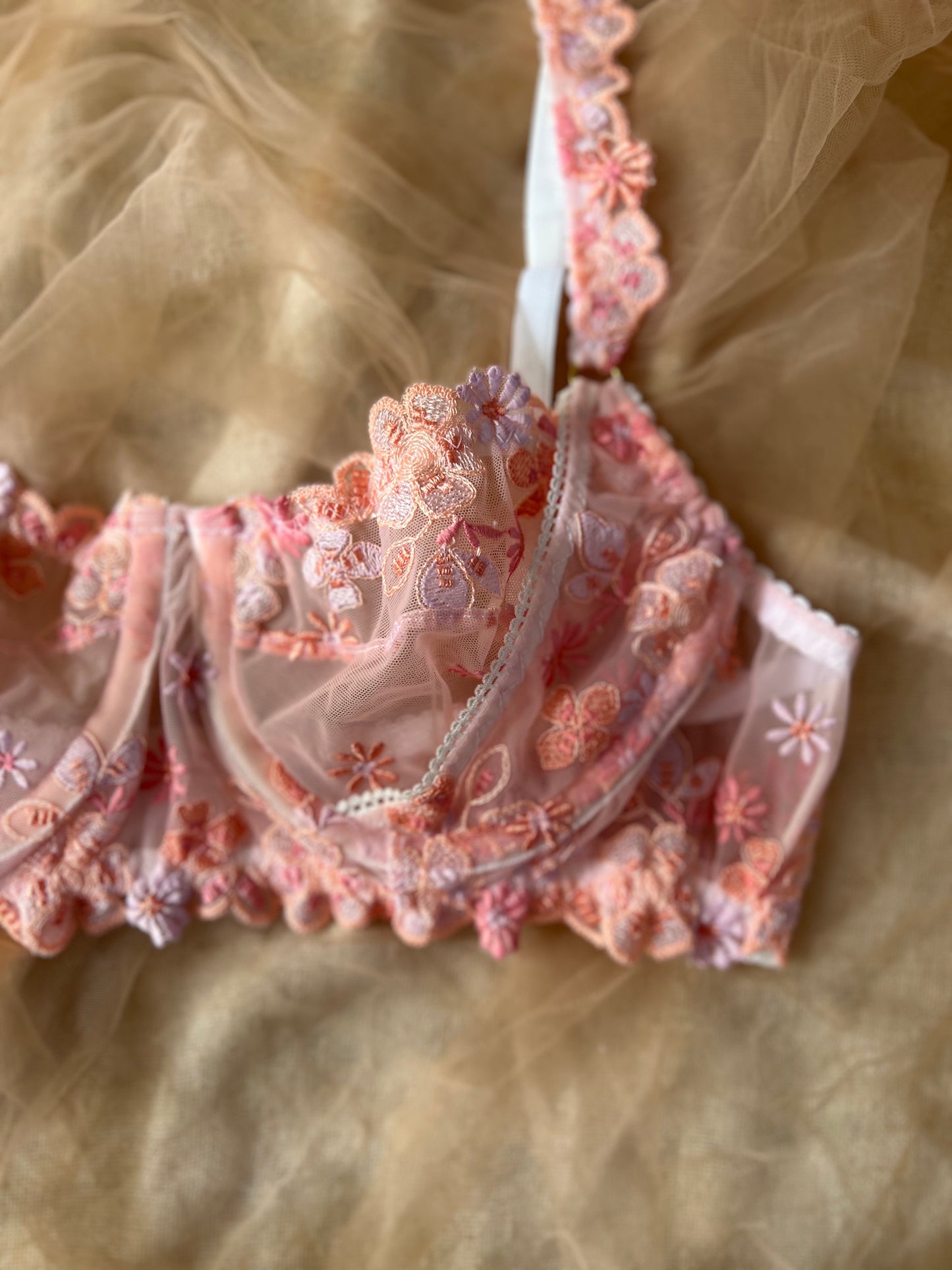 Pink lace bra on a sheer fabric background