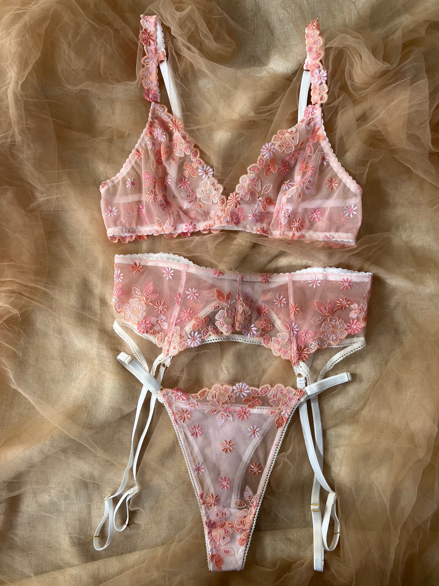 Pink floral lingerie set on a textured brown background