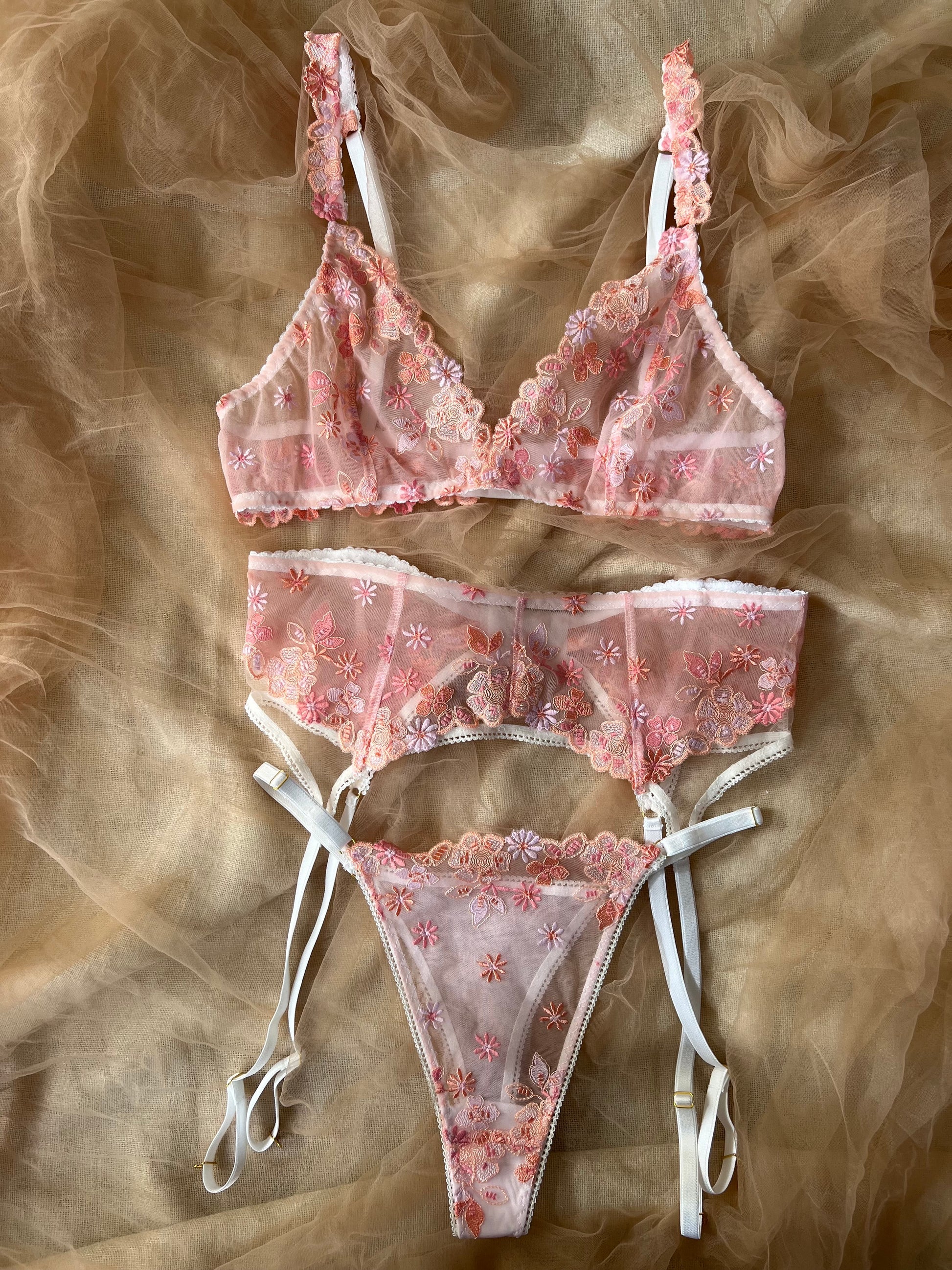 Pink floral lingerie set on a textured brown background