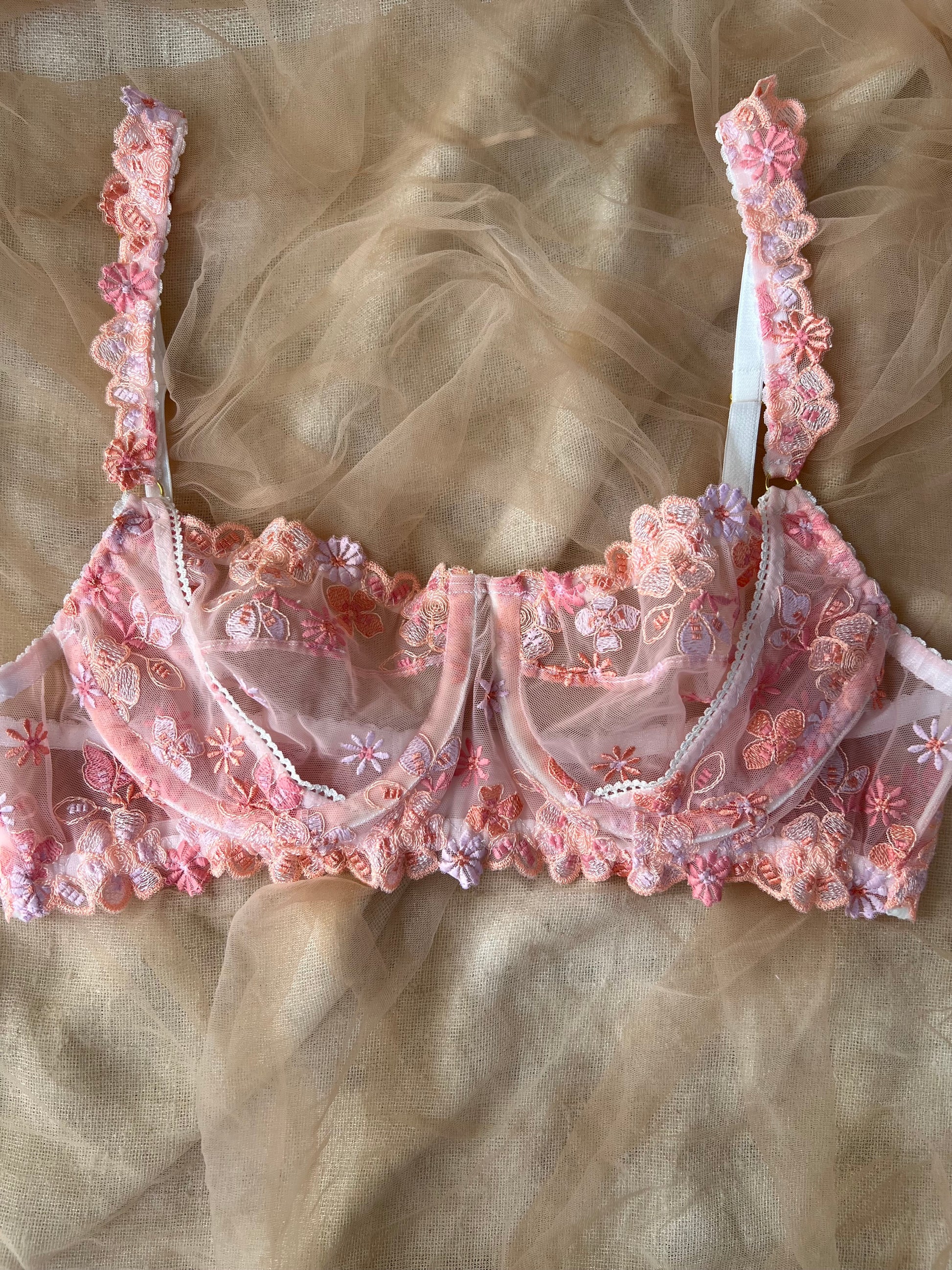 Pink lace bra on a beige fabric background