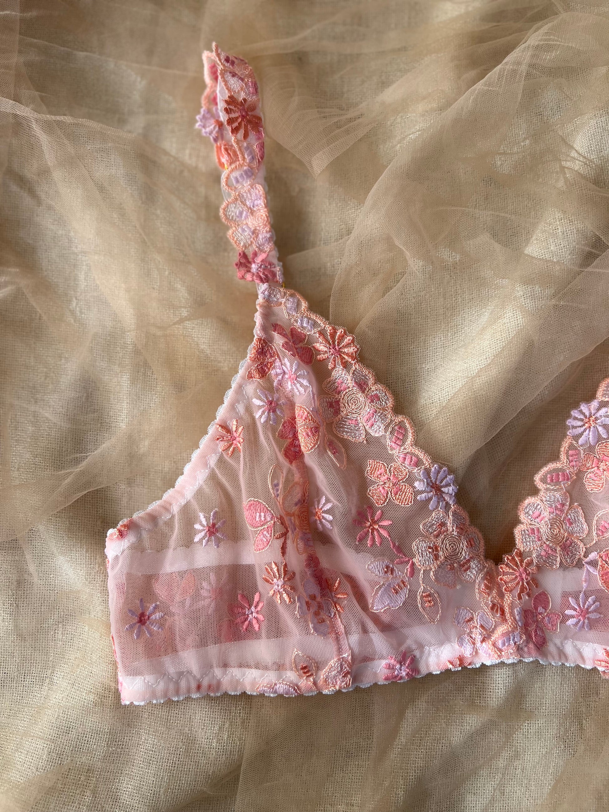 Floral embroidered bralette on a sheer fabric background