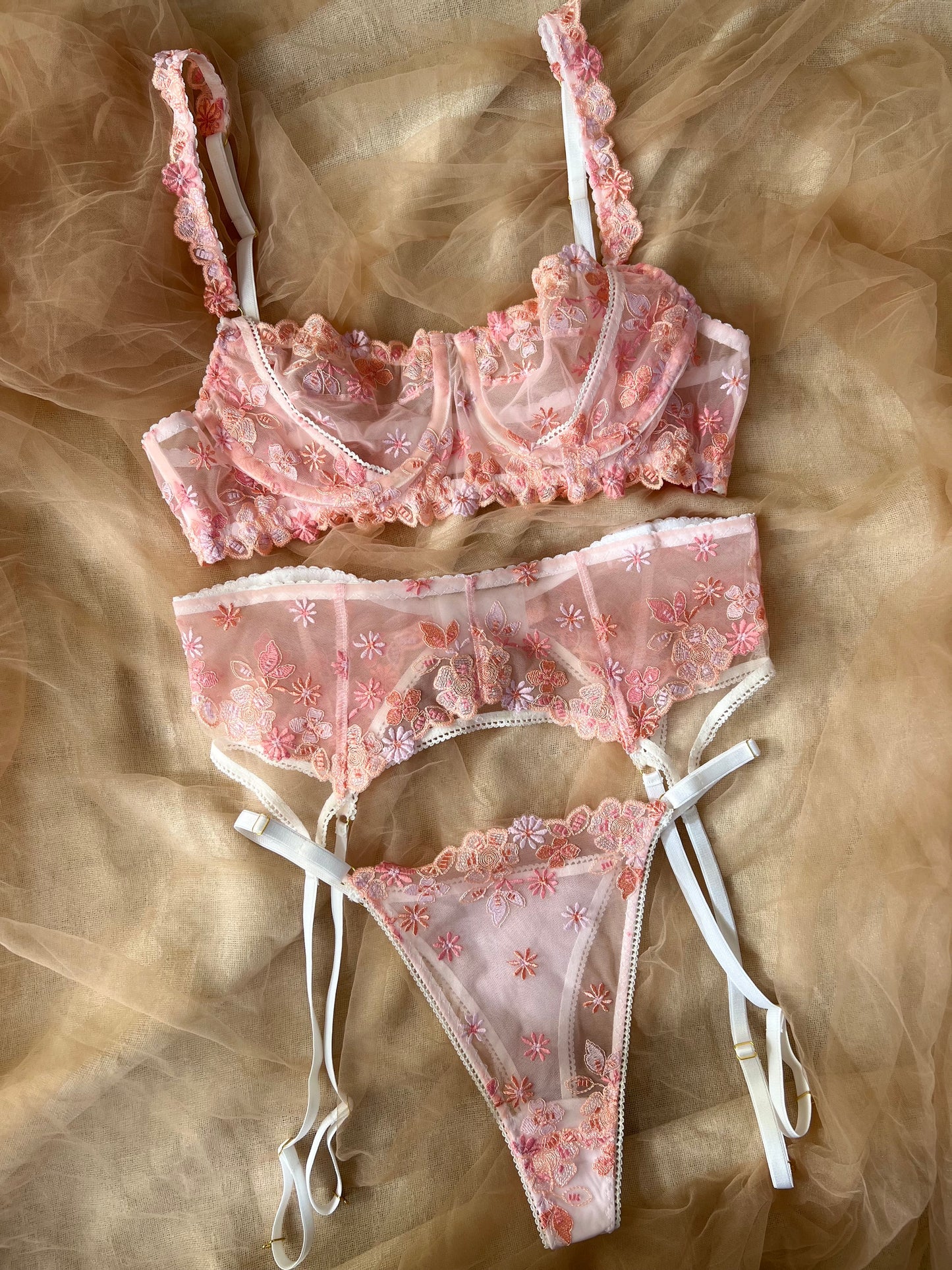 Pink lace lingerie set on a textured brown background