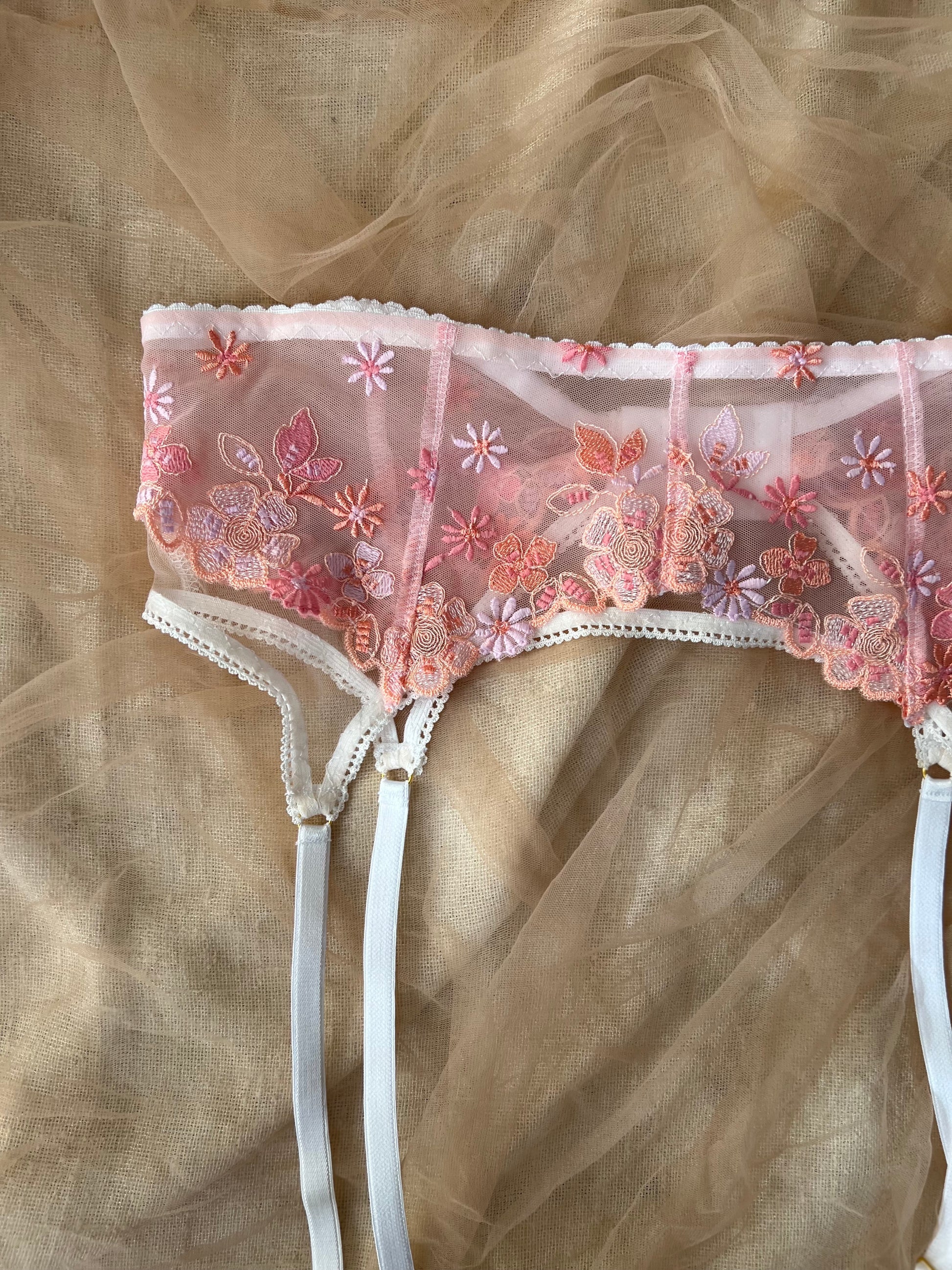 Lace lingerie with floral embroidery on a beige fabric background