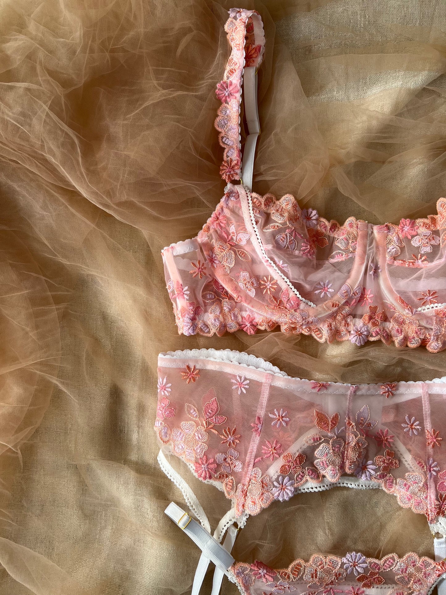 Pink lace lingerie set on a sheer fabric background